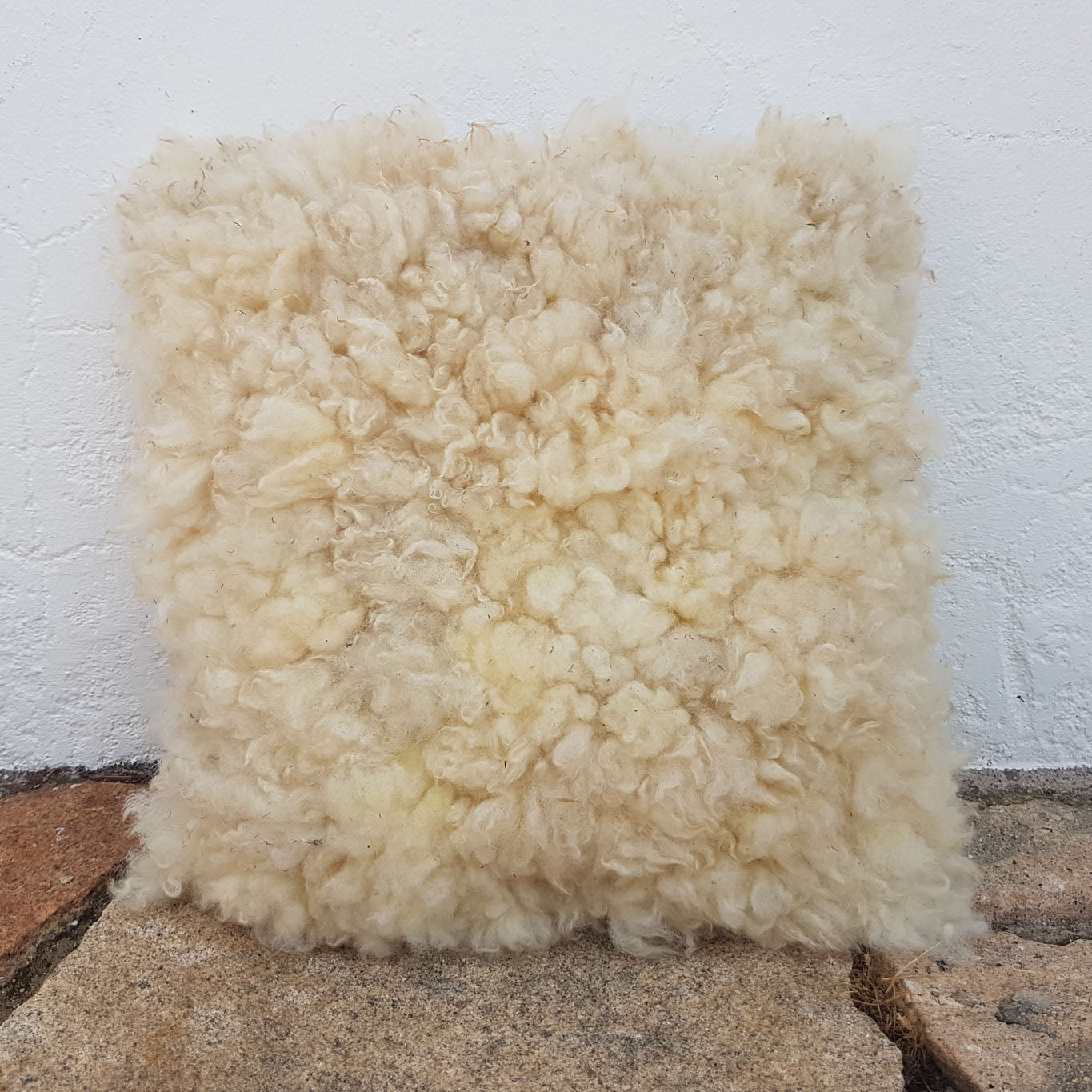 White felted wool cushion with upcycled fabric rear side