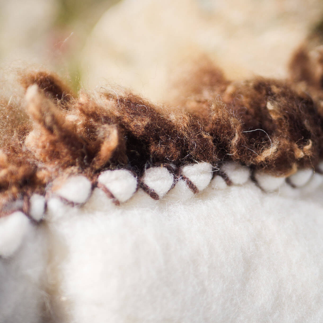 Brown-and-white felted wool cushion